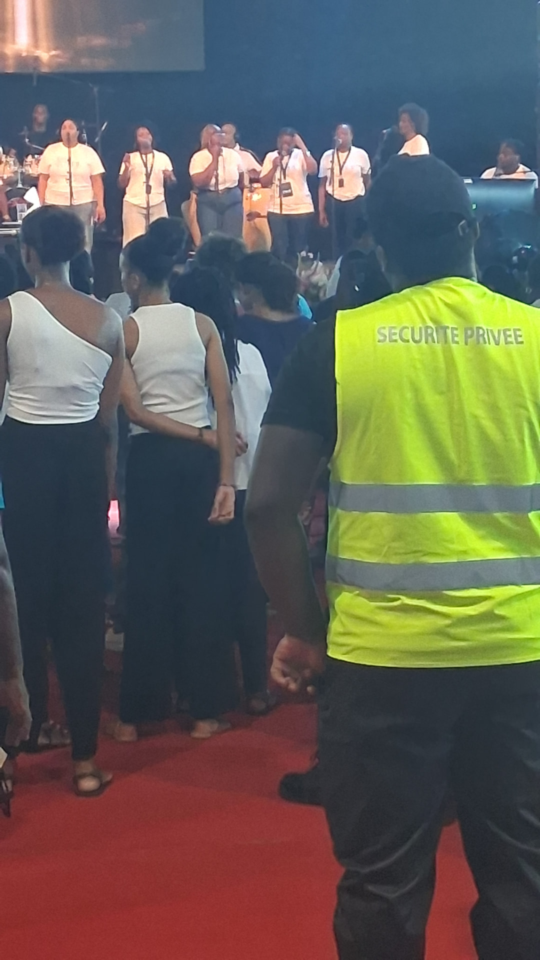 Agent de sécurité privée en gilet haute visibilité encadrant le public lors d'un événement